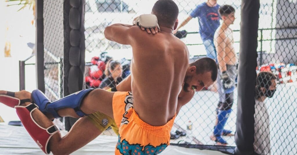 Fighter throws knee strike during muay thai lessons for beginners