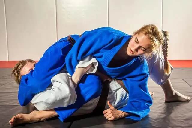 Two students practicing groundwork as part of martial arts basics