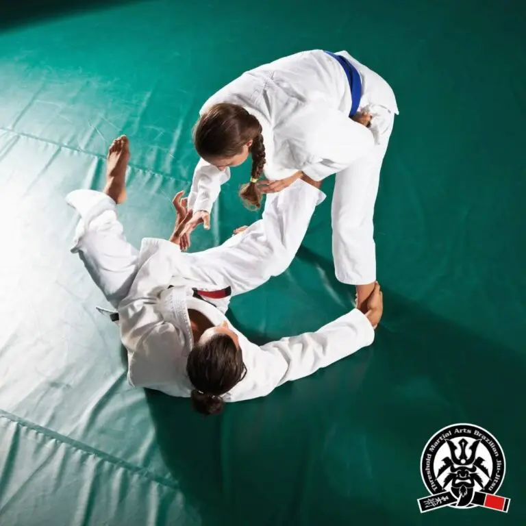 Female practitioner standing and working to break open guard against an opponent on the mat adult Brazilian Jiu Jitsu guard passing principles