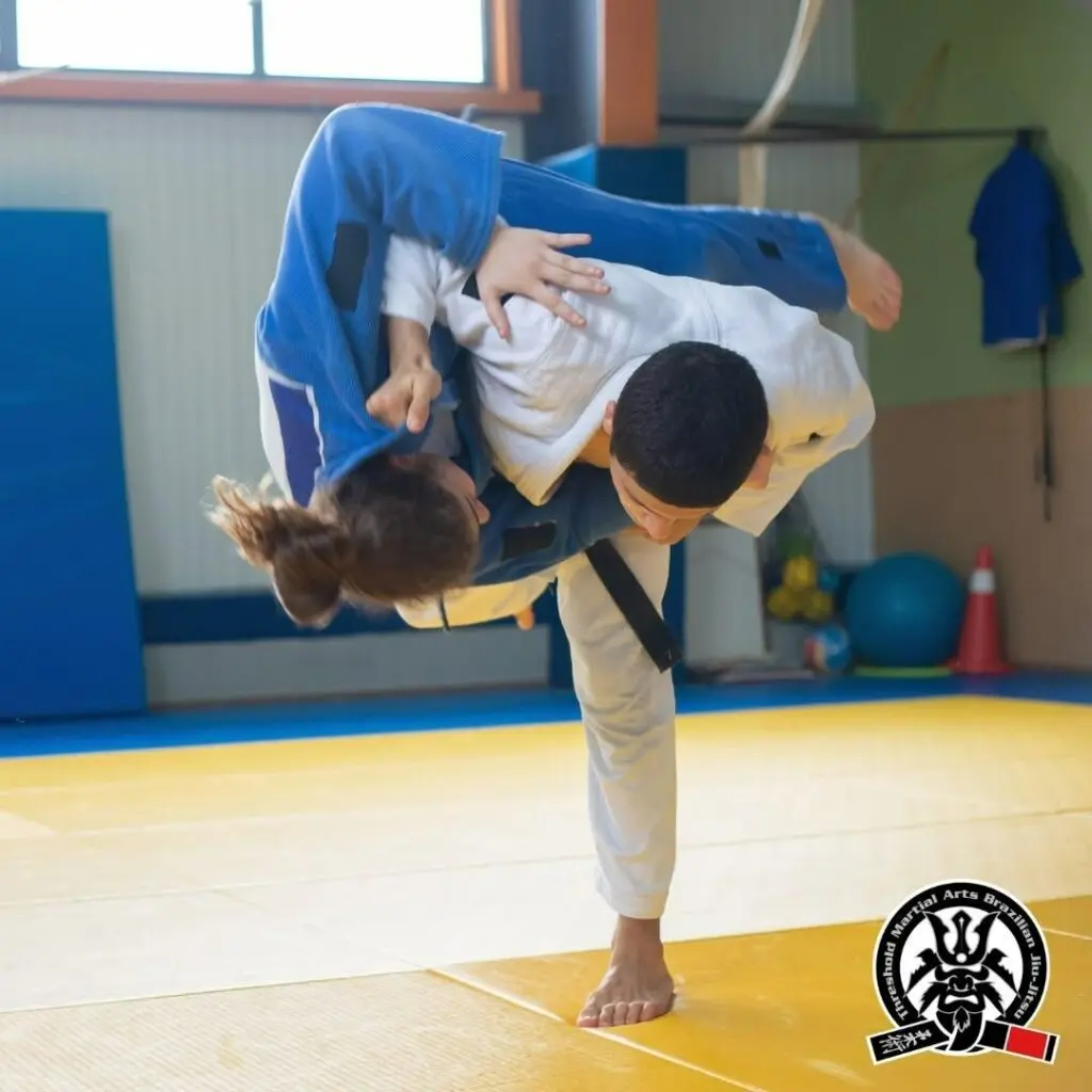 Martial artist executing a high shoulder throw during a partner drill adult Brazilian Jiu Jitsu guard passing principles.